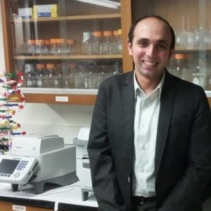 Ahmed El-Hefnawy standing in the lab with a cabinet behind him